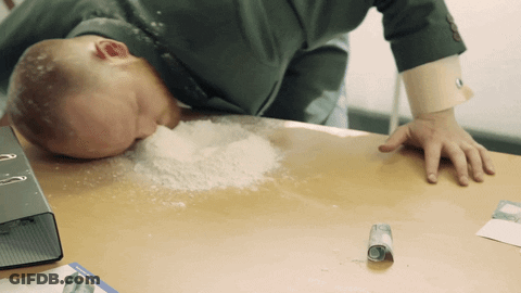 Man Laying On Desk With Powder On Floor GIF