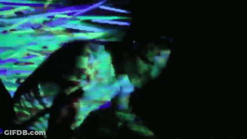 Man Laying On Floor In Dark Room With Green And Purple Light GIF