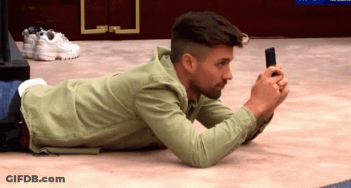 Man Laying On Floor Looking At Cell Phone GIF