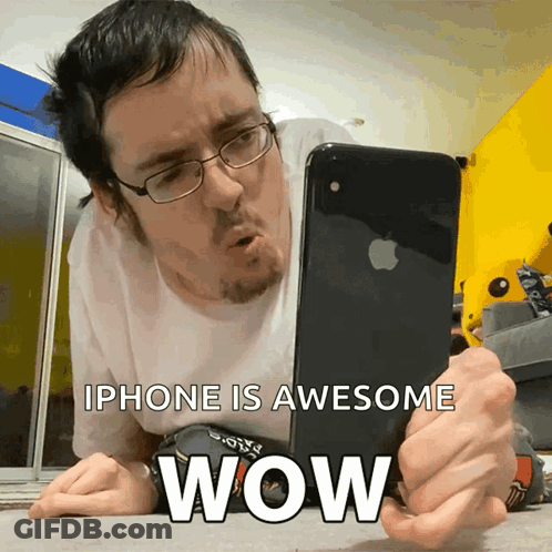 Man Laying On Floor Looking At IPhone Saying IPhone Is Awesome Wow GIF