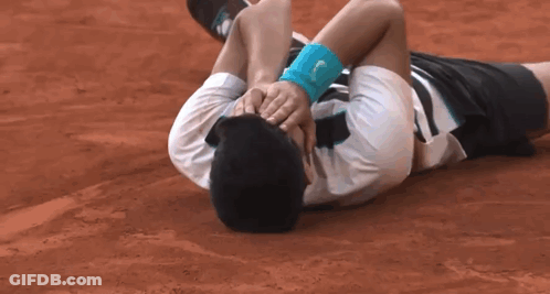 Man Laying On Ground Head In Hands With Wristband GIF