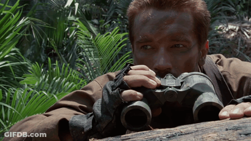 Man Laying On Log Looking Through Binoculars GIF