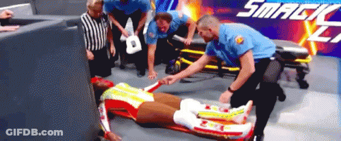 Man Laying On Stretcher In Front Of Smackdown Sign GIF