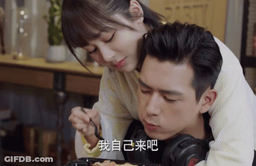 Man Laying On Woman's Lap With Headphones And Chinese Writing On Face GIF