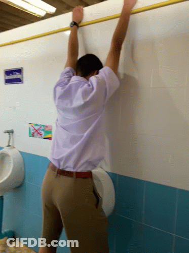 Man Leaning Against Urinal In Bathroom GIF