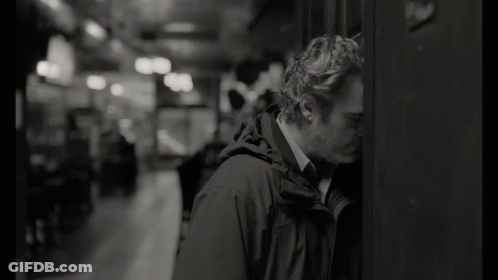 Man Leaning Against Wall With Head Down Black And White GIF