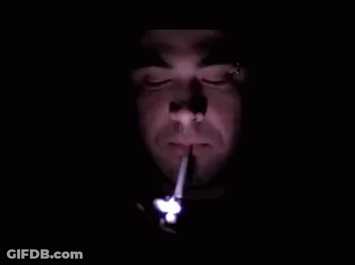 Man Lighting Cigarette In Dark With Lighter GIF
