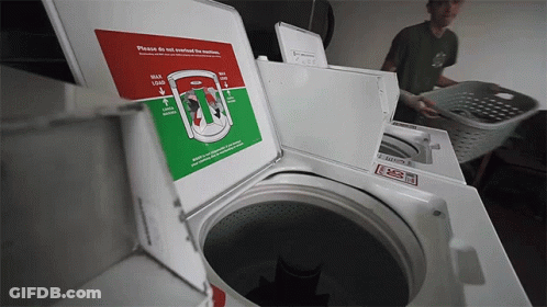 Man Loading Clothes Into Washing Machine Saying Please Do Not Overfill The Machine GIF