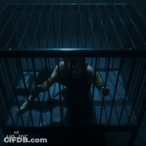 Man Locked In Cage In Dark Room GIF