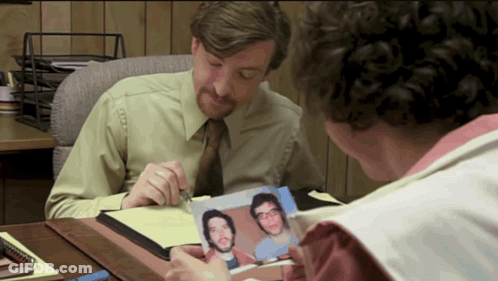 Man Looking At Picture Of Two Men GIF