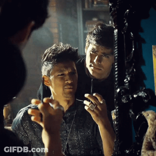Man Looking At Reflection In Mirror Holding Lighter GIF