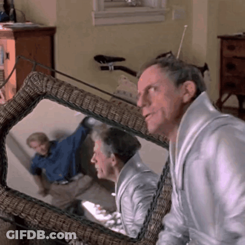Man Looking At Reflection In Wicker Chair GIF