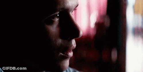 Man Looking Out Window In Dark Room GIF