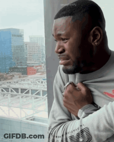 Man Looking Out Window With Scumchanify Watermark GIF