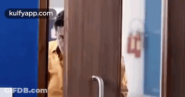 Man Looking Out Wooden Door GIF