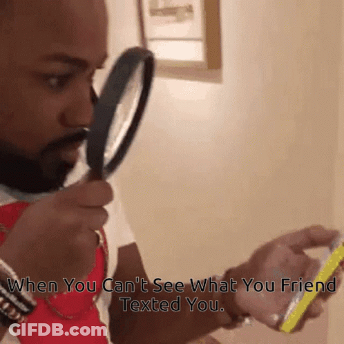 Man Looking Through Magnifying Glass At Phone GIF