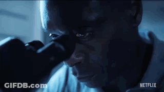 Man Looking Through Microscope In Dark Room GIF