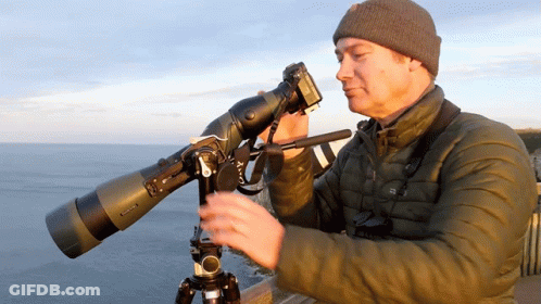 Man Looking Through Telescope With Camera GIF