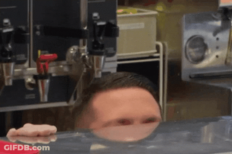 Man Lurking Behind Table GIF