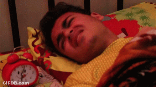 Man Lying In Bed Next To Red Alarm Clock GIF
