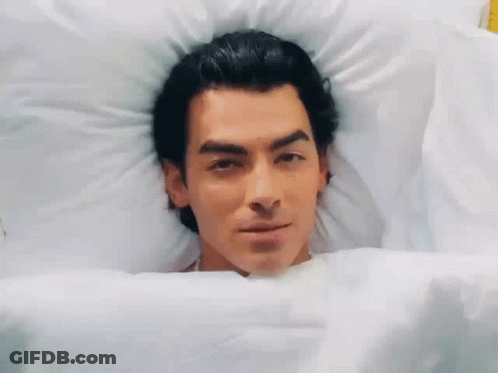 Man Lying In Bed Smiling GIF