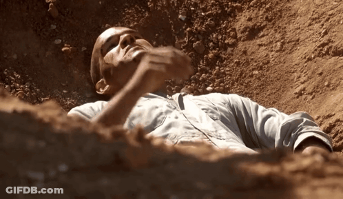 Man Lying In Dirt With Hand On Face GIF