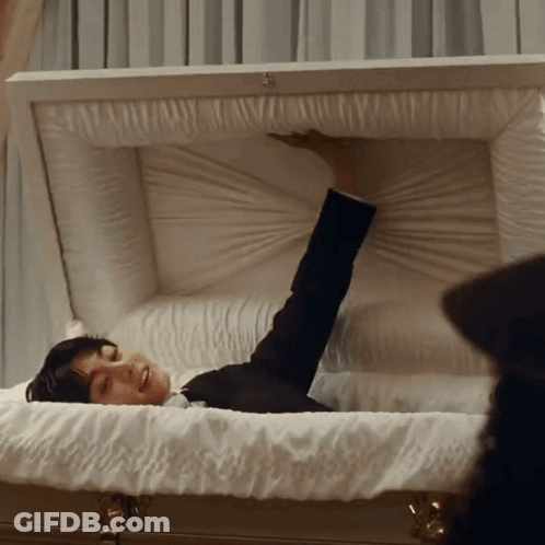 Man Lying In White Coffin Arm Outstretched GIF
