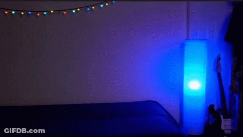 Man Lying On Another's Back In Dark Room With Blue Lamp GIF