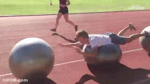 Man Lying On Ball On Track GIF