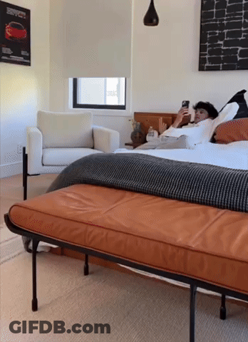 Man Lying On Bed Looking At Cell Phone GIF