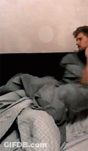 Man Lying On Bed With Gray Blanket GIF