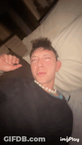 Man Lying On Bed With Necklace GIF