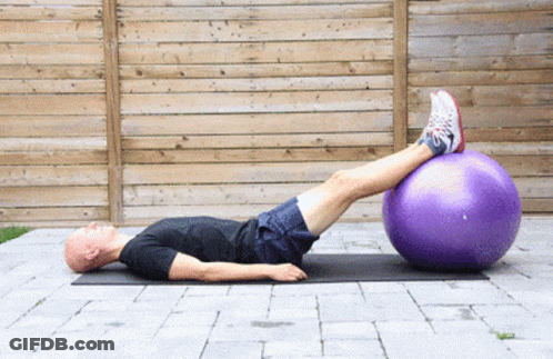 Man Lying On Mat With Legs On Purple Ball GIF