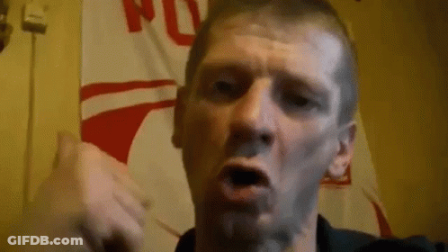 Man Making Funny Face In Front Of Flag Wall GIF