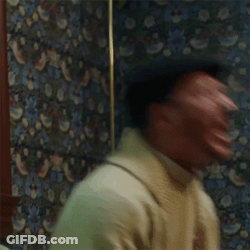 Man Making Funny Face In Front Of Patterned Wallpaper GIF