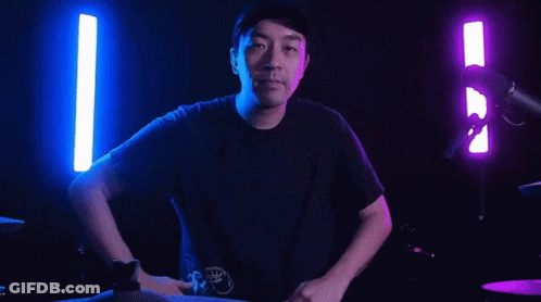 Man Making Heart Shape At Microphone In Dark Room GIF