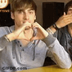 Man Making Heart Shape With Hands At Table GIF