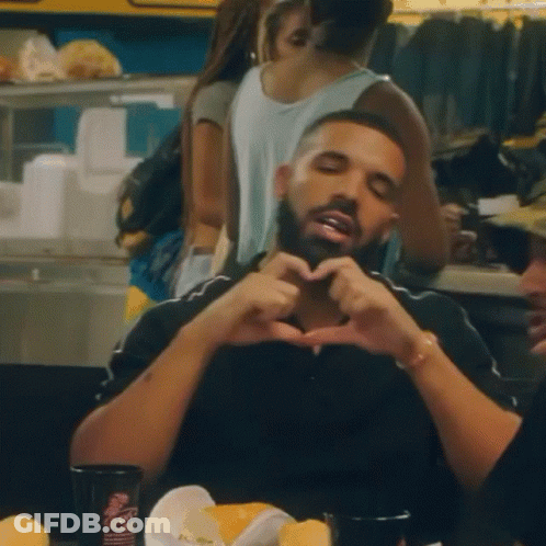 Man Making Heart Shape With Hands At Table GIF