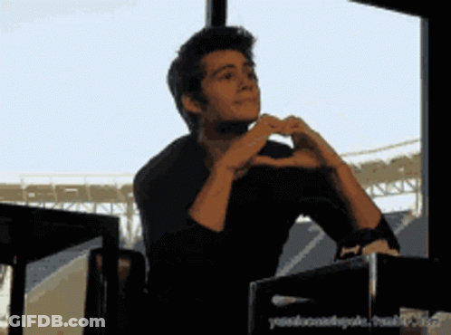 Man Making Heart Shape With Hands In Front Of Window GIF