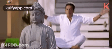 Man Meditating Before Buddha Statue GIF