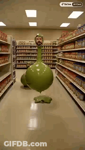 Man Next To Green Long-Neck Balloon In Grocery GIF