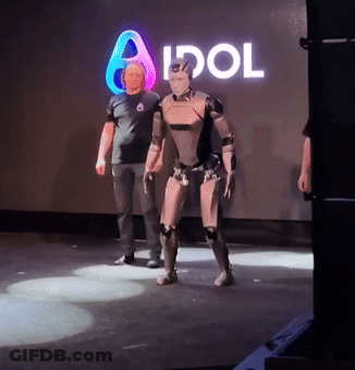 Man Next To Robot In Front Of Idol Sign GIF