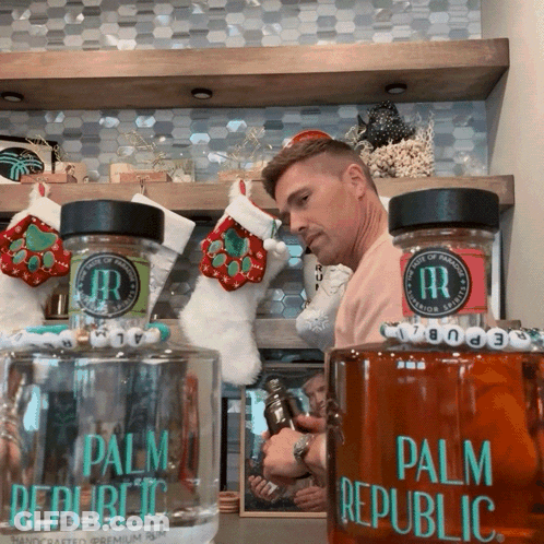 Man Next To Two Palm Republic Bottles GIF