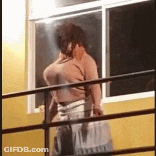 Man On Balcony Talking On Cell Phone GIF