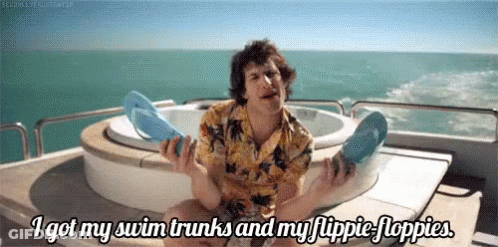Man On Boat Holding Flip Flops Saying I Got My Swim Trunks GIF
