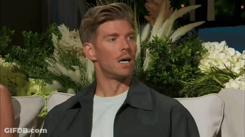Man On Couch Making Funny Face With Flowers GIF