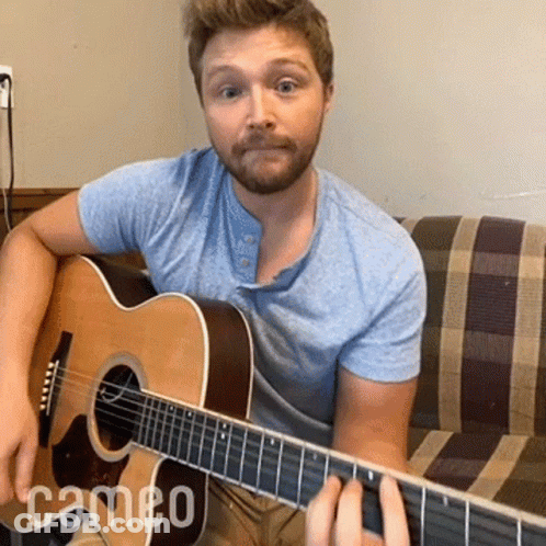 Man On Couch Playing Acoustic Guitar With Cameo Text GIF