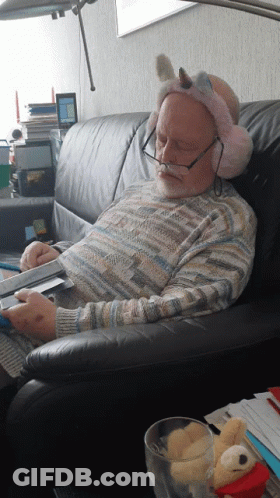 Man On Couch With Ear Muffs Unicorn Headband GIF