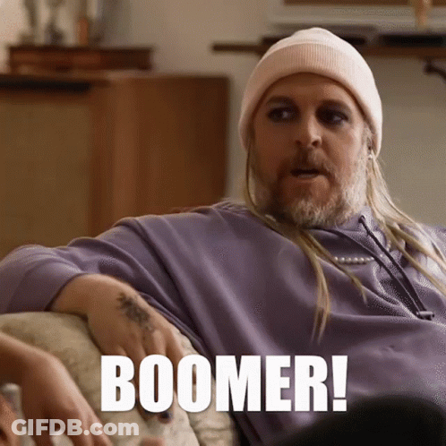 Man On Couch With Long Hair And Beanie Says Boomer GIF