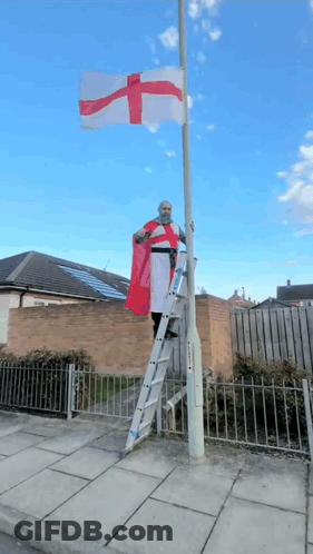 Man On Ladder Holding Red And White Cross Flag GIF